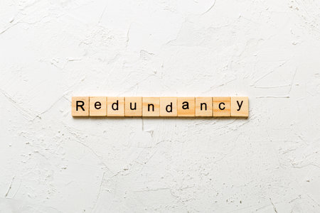 redundance word written on wood block. redundance text on table, conceptの写真素材