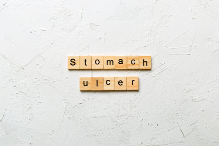 stomach ulcer word written on wood block. stomach ulcer text on table, concept.の写真素材