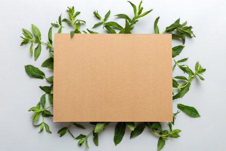 Wreath frame made of empty paper blank with space for text and mint leaves on colored background. . Mint Pattern. Flat lay. Top view.の写真素材