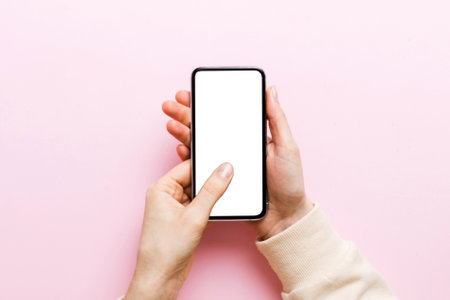 Top view of woman hands holding smart phone with blank copy space screen for your text message or information content. woman hand using phone white screen on top view.の写真素材