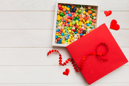 Valentine day composition: sweet candy, with gift boxes with and red felt hearts, photo bow template, background. Top View with copy space.の写真素材