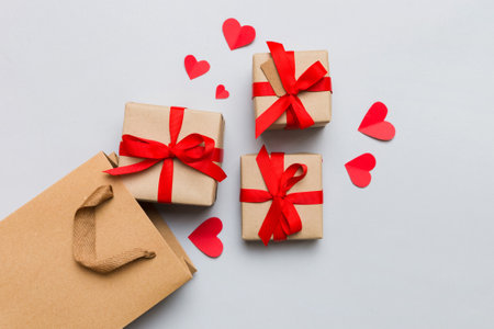 Gift boxes pop out from paper bag top view on colored background. bag packing handmade boxes fall out Concept of holidays, shopping, sale, discounts. Top view, flat lay.の写真素材