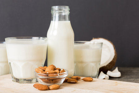 Set or collection of various vegan milk almond, coconut, cashew, on table background. Vegan plant based milk and ingredients, top view.の写真素材