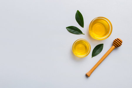 Honey jar with wooden honey dipper on white background top view with copy space.の写真素材