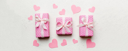 Valentine day composition Background: pink gift box with bow and heart. Holiday greeting card. View from above.の写真素材