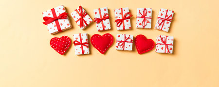 Holiday composition of gift boxes and red textile hearts on colorful background with empty space for your design. Top view of Valentine's Day concept.の写真素材