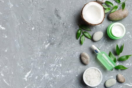 Coconut with jars of coconut oil and cosmetic cream on colored background. Top view. Free space for your text. Natural spa coconut cosmetics and organic treatment concept Coconut Spa composition.の写真素材