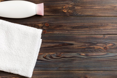 Cosmetic shampoo bottle mockup with towels on a colored table. Bathroom background, toilet accessories for hand and body care.の写真素材