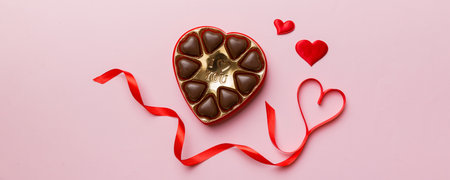 Delicious chocolate pralines in red box for Valentine's Day. Heart shaped box of chocolates top view...