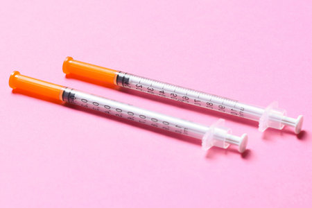 Top view of two insulin syringes at colorful background. High level of glucose concept.の写真素材