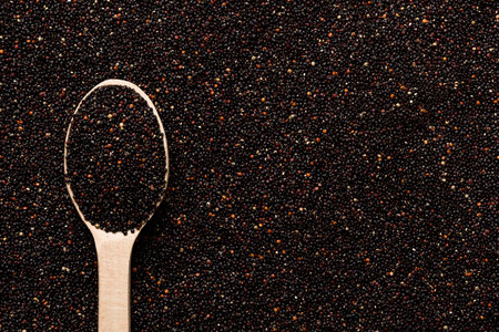 black quinoa grain in wooden spoon background and texture of gluten free top view.の写真素材