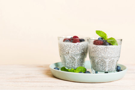 Healthy breakfast or morning with chia seeds vanilla pudding raspberry and blueberry berries on table background, vegetarian food, diet and health concept. Chia pudding with raspberry and blueberry.の写真素材