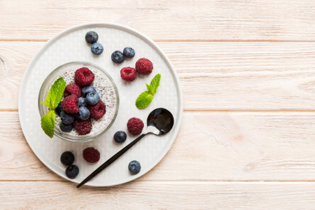 Healthy breakfast or morning with chia seeds vanilla pudding raspberry and blueberry berries on table background, vegetarian food, diet and health concept. Chia pudding with raspberry and blueberry.の写真素材