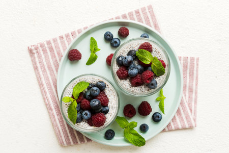 Healthy breakfast or morning with chia seeds vanilla pudding raspberry and blueberry berries on table background, vegetarian food, diet and health concept. Chia pudding with raspberry and blueberry.の写真素材