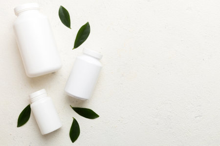 supplement pills with medicine bottle health care and medical top view. Vitamin tablets. Top view mockup bottle for pills and vitamins with green leaves, natural organic bio supplement, copy space.の写真素材