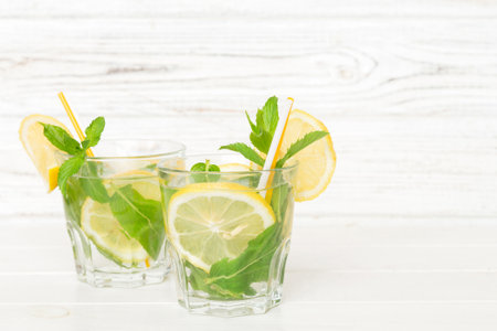 Mojito cocktail. Refreshing mojito cocktail with lime, lemon and mint in a tall glass with a stick.の写真素材