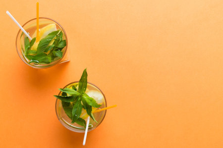 Caipirinha, Mojito cocktail, vodka or soda drink with lime, mint and straw on table background. Refreshing beverage with mint and lime in glass top view flat lay.の写真素材