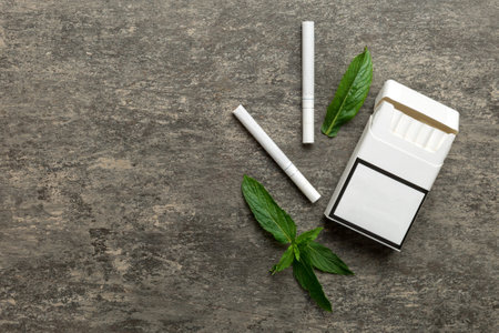 Pack of menthol cigarettes and fresh mint on colored table, Menthol cigarettes top view flat lay.