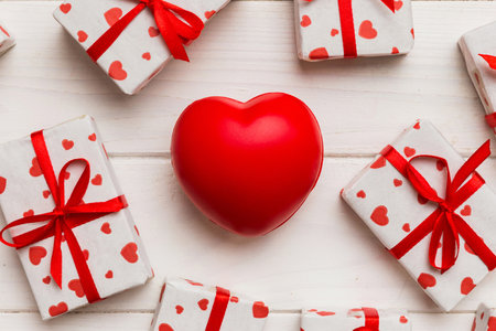 gift box with red bow and red heart on colored background. Top view. Flat lay.