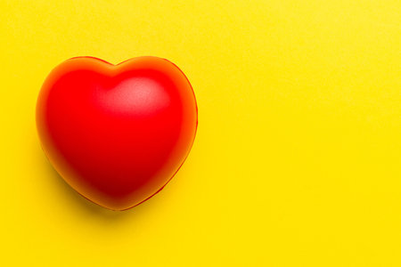 red heart shape on colored background. minimal concept top view with copy space.の写真素材