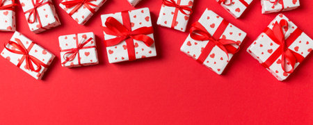 Holiday composition of gift boxes with red hearts on colorful background with empty space for your...