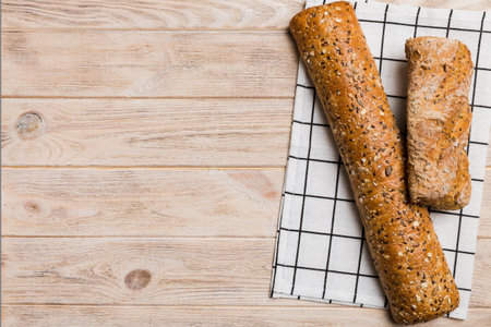 fresh crunchy French baguette on colored table. Top view Bakery products.