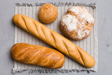 Assortment of freshly baked bread with napkin on rustic table top view. Healthy unleavened bread.
