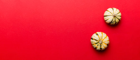 Autumn composition of little orange pumpkins on colored table background. Fall, Halloween and Thanksgiving concept. Autumn flat lay photography. Top view with copy space.の写真素材