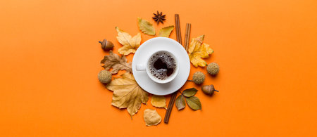 Flat lay composition with colorful Autumn cup of coffee and leaves on a color background. top view.の写真素材