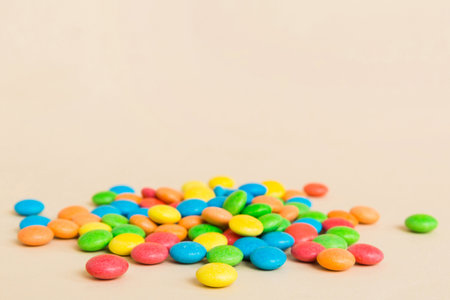 Pile of delicious colorful sweet candies on colored background top view. Confectionery decor.
