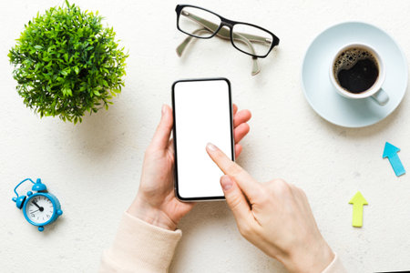Top view of woman hands holding smart phone with blank copy space screen for your text message or...