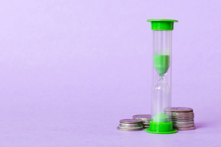 Deadline and time is money concept with hourglass and US coins currency. sand clock time for saving...