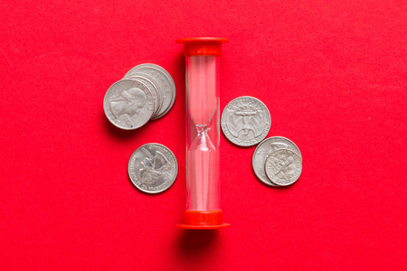 Deadline and time is money concept with hourglass and US coins currency. sand clock time for saving...