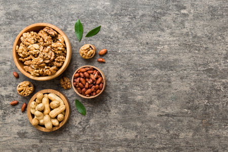 Walnut kernel halves, in a wooden bowl. Close-up, from above on colored background. Healthy eating...