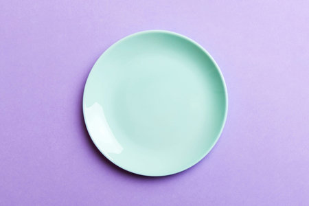 Top view of isolated of colored background empty round blue plate for food. Empty dish with space for your design.