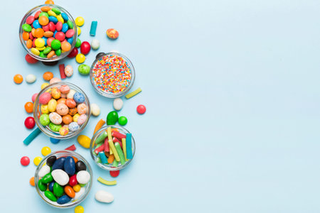 different colored round candy in bowl and jars. Top view of large variety sweets and candies with copy space.