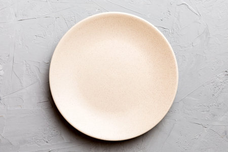 Top view of empty light plate on cement background. Empty space for your design.