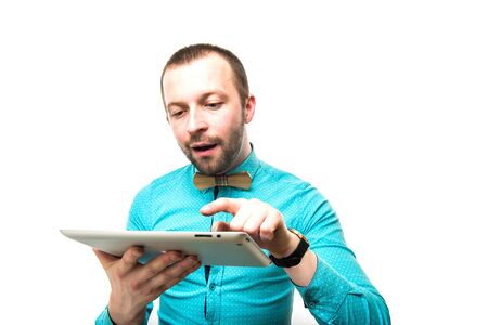 a guy with a tablet in hand, looks at him and laughsの写真素材