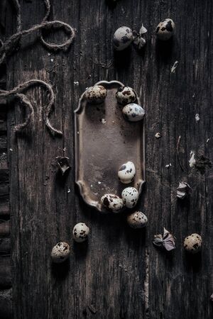 quail eggs lying on a wooden surface in a metal trayの写真素材