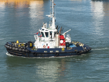 Tugboat cruising in harbor waiting for the next ship to pull in.