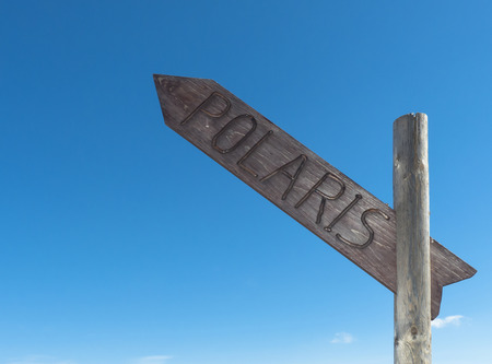 Signpost with writing Polaris directing north against blue sky.の写真素材