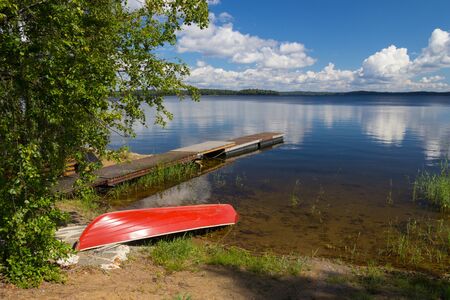 Finland lake with boat and cloudsの写真素材