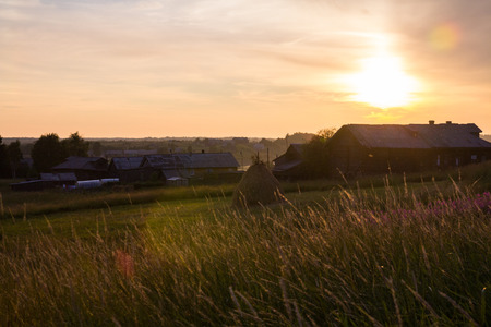 Evening in the village. setting sun above the housesの写真素材