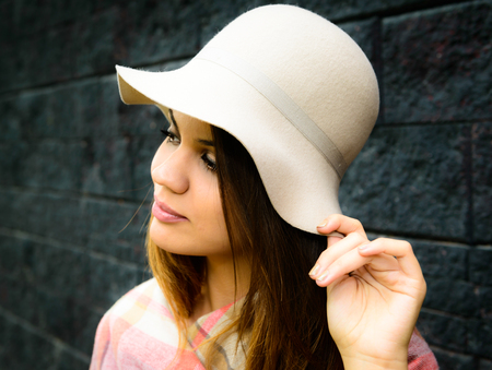 a young woman is touching her white hatの写真素材