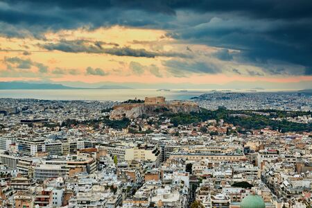 Acropolis of Athens Greece at cloudy sky sunset with the sea and mountains at the backgroundの写真素材