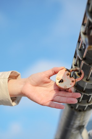 Padlock in the shape of a heart on the palm. Checking the strength of the conceptの写真素材