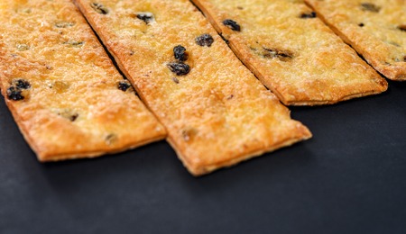 Sweet cookies with raisins. Pastry strips on black background.の写真素材