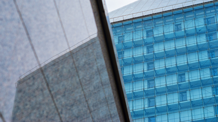 Modern building background. Glass facade in the reflection of the polished granite wall