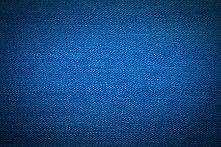 Texture of blue jeans textile close up. Blank backdrop for design. Effect of lens vignettingの写真素材