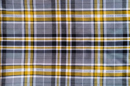 Fabric for clothing background. Grey and yellow cloth in a cage as blank backdropの写真素材